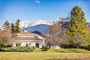 a house in a field with mountains in the background at Villa Architecte des années 70 in Vif