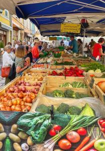 a market with many boxes of fruits and vegetables at Le Petit Delphia in Apt +44 photos