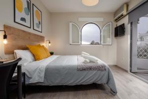 a bedroom with a large bed and two windows at Nordik Rooms Urban - Segalerva "Geiranger" in Málaga