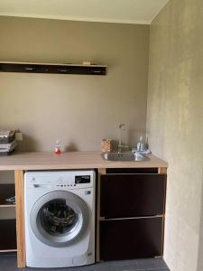 a kitchen with a washing machine and a sink at A Cozy Retreat - Sauna & Garden - 3BDR in Pärnamäe