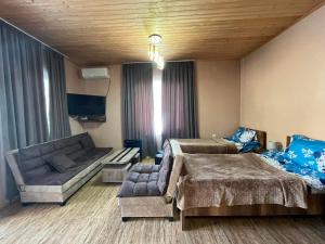 Lela Guest House في ميستيا: غرفة معيشة بها سريرين وأريكة