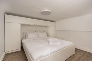 a white bedroom with a large white bed at Cosy Nest in Athens 4' to Metro Station Petralona in Athens