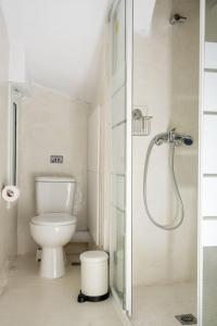 a white bathroom with a toilet and a shower at Cosy Nest in Athens 4' to Metro Station Petralona in Athens