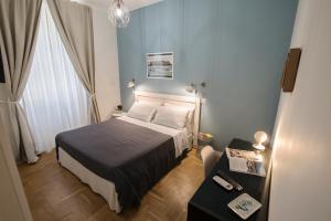 um pequeno quarto com uma cama e uma mesa em The Andy House B&B em Nápoles