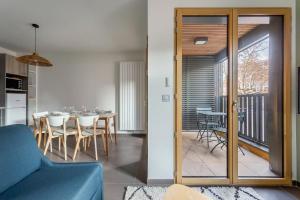 uma sala de estar com um sofá azul e uma sala de jantar em Suite Croix-Rousse : T3 avec patio ! em Lyon