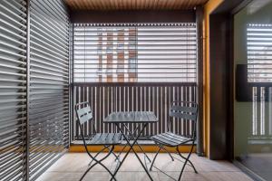 Suite Croix-Rousse : T3 avec patio ! في ليون: شرفة مع طاولة وكرسيين أمام النافذة
