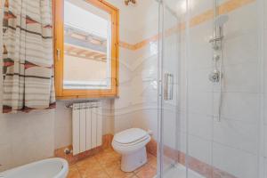 a bathroom with a toilet and a glass shower at Appartamenti Norsi in Capoliveri +49 photos