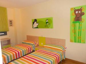 Dos camas en un dormitorio infantil con sábanas de colores. en Bright Apartment in Alicante, 90 m², Shared Pool, en Alicante 5 fotos más