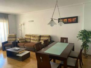 una sala de estar con una mesa y un sofá en Bright Apartment in Alicante, 90 m², Shared Pool, en Alicante