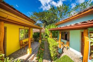 a house with yellow walls and a patio at Hotel Arco Iris in Tamarindo