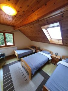 a attic room with three beds and a window at Orion in Borzont