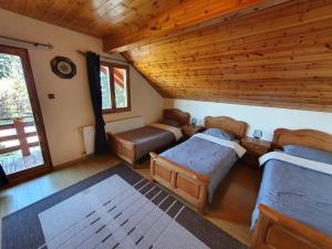 1 Schlafzimmer mit 2 Betten und Holzdecke in der Unterkunft Orion in Borzont