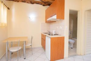una cucina con tavolo, lavandino e servizi igienici di Sunrise Sissi Apartments a Sissi Altre 10 foto