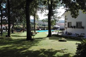 een huis met een hangmat in een tuin met bomen bij 2 bedrooms house with private pool terrace and wifi at Paredes de Coura in Paredes de Coura