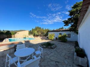 un patio con mesa, sillas y piscina en 3 bedrooms house with private pool terrace and wifi at Albinyana, en Albinyana