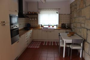 uma cozinha com uma mesa e um fogão forno superior em 2 bedrooms house with private pool terrace and wifi at Paredes de Coura em Paredes de Coura