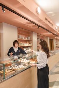 Una donna sta preparando il cibo in una pasticceria di Moderno Hotel Roma a Roma