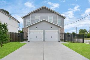 a gray house with a garage in a driveway at Rodeo Ready!!!! Modern 3 bedroom home in Houston