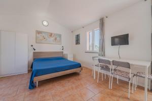 a bedroom with a bed and a table and chairs at Appartamenti Norsi in Capoliveri