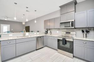 a kitchen with white cabinets and stainless steel appliances at Rodeo Ready!!!! Modern 3 bedroom home in Houston
