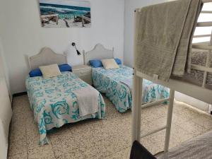 プンタ・ウンブリアにある4 bedrooms house at Punta Umbria 100 m away from the beach with terrace and wifiのベッドルーム1室(ベッド2台付)が備わります。壁に絵が描かれています。