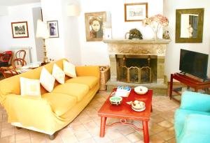 sala de estar con sofá amarillo y chimenea en 4 bedrooms appartement with terrace and wifi at Barbarano Romano, en Barbarano Romano