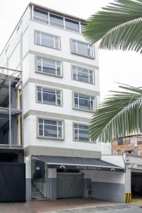 un edificio blanco con un toldo negro delante de él en Hotel Rosales Gold en Pereira
