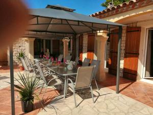 - une table et des chaises sous un parasol sur la terrasse dans l'établissement Villa de 6 chambres avec piscine partagee et wifi a Sainte Valiere, à Sainte-Vallière