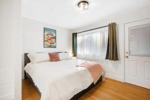a white bedroom with a bed and a window at Mount Walker Suite, Room 12 at Mount Walker Inn in Quilcene