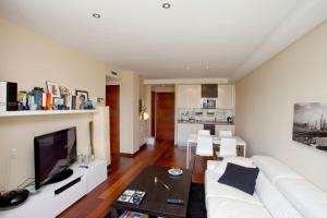 een woonkamer met een witte bank en een tv bij One bedroom apartement with wifi at Mislata in Valencia