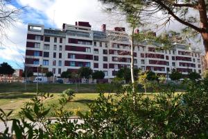 ein großes weißes Gebäude mit Bäumen davor in der Unterkunft Comfortable Apartment in Mislata - 50 m² - Parking Included in Valencia
