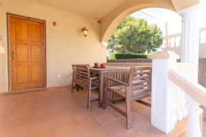 a patio with a table and chairs and a wooden door at INNOUTHOME CASA CON PISCINA Av AMETLLA DE MAR in L'Ametlla de Mar