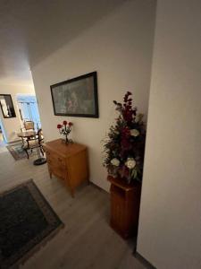 uma sala de estar com um arranjo de flores numa cómoda em City Hotel Post 22 em Braunau am Inn