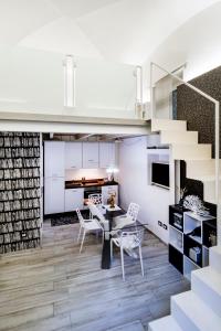 a kitchen and dining room with stairs and a table and chairs at Stesicoro Exclusive House in Catania