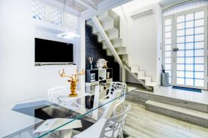 a dining room with a glass table and white chairs at Stesicoro Exclusive House in Catania