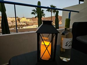 a candle and a bottle of wine on a table at Ocean & Pool view apartament in Playa del Cura