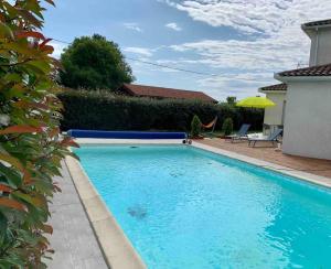 une grande piscine bleue en face d'une maison dans l'établissement Villa de 2 chambres avec piscine privee terrasse et wifi a Saint Gaudens, à Saint-Gaudens