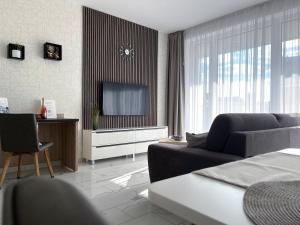 a living room with a couch and a television at Spa Residence Carbona 101, 307 Apartman in Hévíz