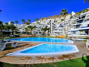 a swimming pool in front of a large apartment building at Ocean & Pool view apartament in Playa del Cura
