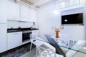 a kitchen with a glass table and white cabinets at Stesicoro Exclusive House in Catania