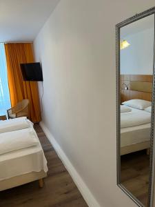 a mirror in a hotel room with two beds at City Hotel Post 22 in Braunau am Inn