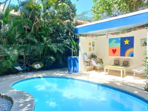 a swimming pool in a backyard with a house with a playground at Calma Apartments Costa Rica in Mal País