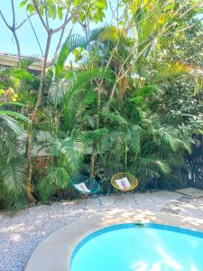 two chairs sitting next to a swimming pool at Calma Apartments Costa Rica in Mal País