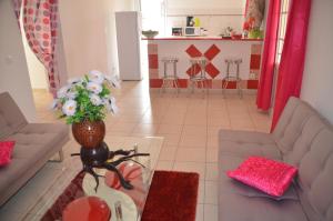 a living room with a couch and a vase of flowers at Ô PARADIS TERRESTRE in Capesterre