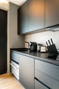a kitchen with black and white counters and cabinets at Studio with wifi at Sevilla in Seville
