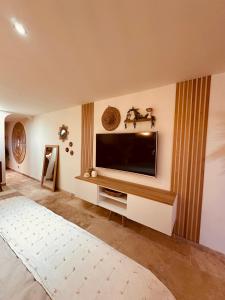 uma sala de estar com uma televisão de ecrã plano na parede em LoveRoom, La suite de l’extase em Puget-sur Argens
