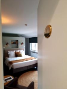 Schlafzimmer mit einem Bett und einem Fenster in der Unterkunft Chambres d'hôtes - Au Clos d'Amande in Lasne
