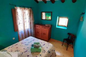 1 dormitorio con cama, silla y espejo en 3 bedrooms house with shared pool and terrace at Ores, en Orés