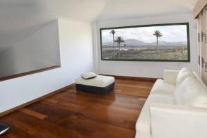 ein Wohnzimmer mit einem weißen Sofa und einem Fenster in der Unterkunft 4 bedrooms chalet with shared pool and wifi at Yaiza in Yaiza