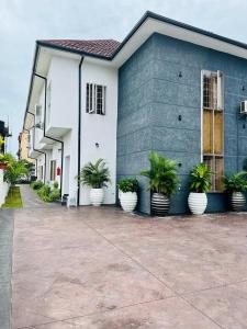 a house with a bunch of potted plants on it at Diaggello Homex Apartment in Lekki